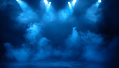 The image shows four bright blue spotlights illuminating a dark stage filled with blue smoke or haze, creating a dramatic and atmospheric effect.