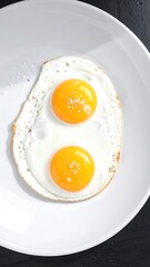 Two fried eggs on a white plate
