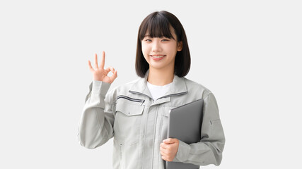 OKポーズをする作業服を着た若い女性・作業員