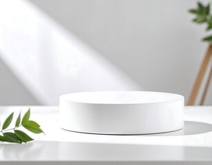 White circular pedestal on a white surface with natural light