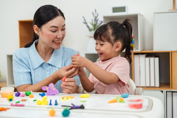 toddler girl with mother sculpting from plasticine at home
