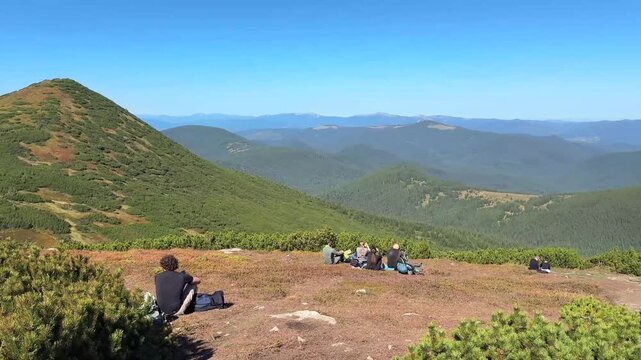 group of tourists relaxing on a mountain summit