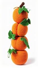 Tall Stack of Knitted Orange Pumpkins with Green Leaves on White Backdrop