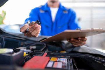 Mechanic inspecting car engine fuse for vehicle maintenance