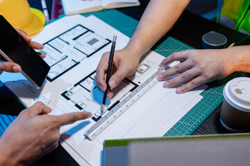 A group of engineers and architects collaborate on a construction project, discussing ideas and...