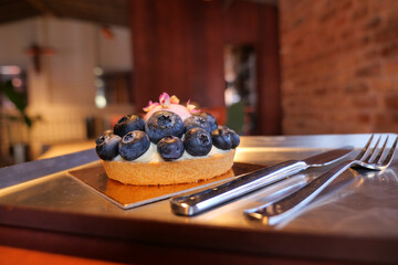 Blueberry tart served in a cozy cafe setting