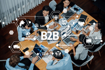 A diverse team of professionals collaborates on B2B strategies and e-commerce solutions, utilizing technology and modern tools in a stylish office environment. Amity