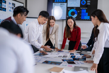 Asian business team analyzing charts and reports in office meeting room