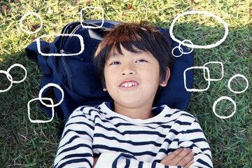 寝転んで想像力を働かせて空想するアジアの日本人の小学生の男の子