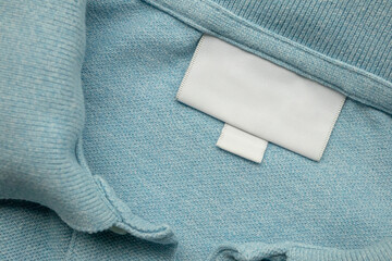 White blank laundry care clothes label on shirt fabric background