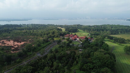 Obraz premium Panoramic aerial vista of a luxurious golf estate, vibrant forests, and serene coastal waters