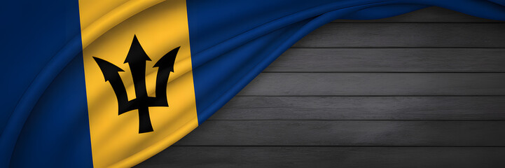 Barbados flag waving proudly with trident emblem on a dark wooden surface, representing national identity.