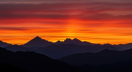 Dramatic sunset over mountain range with fiery orange and red sky