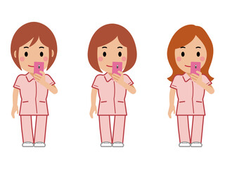 スマホを見るピンクの制服の女性看護師