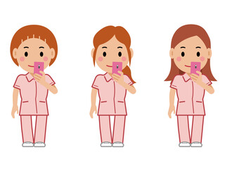スマホを見るピンクの制服の女性看護師。その2