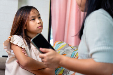 Asian Mother Arguing with Daughter Over Smartphone Use at Home