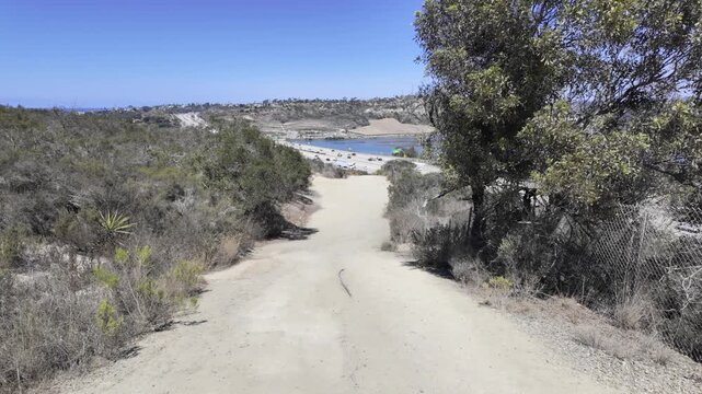 Visitors explore the winding sandstone passages of Annie&rsquo;s Canyon Trail near Solana Beach. The shot reveals the contrast between shaded canyon walls and open blue sky near San Diego, California.