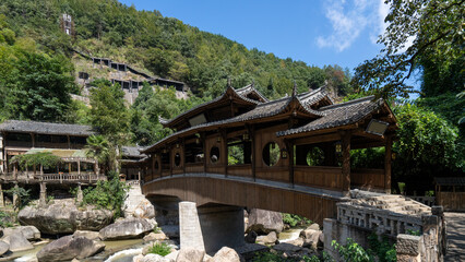 Traditional Chinese wooden bridge surrounded by lush greenery