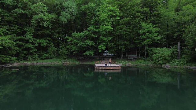 Tourist sightseeing at Lake Biograd in Biogradska Gora National Park in summer, Aerial pullback shot