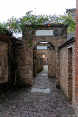Fototapeta premium Old brick archway in a narrow historical alleyway