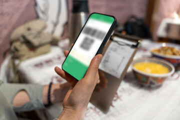 Person using mobile phone to scan QR code in a casual setting