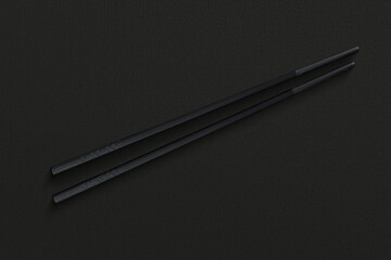Pair of reusable chopsticks on dark background