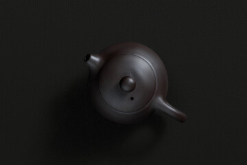Ceramic teapot with lid and spout, top view on dark background