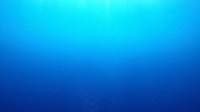 Abstract blue and cyan gradient background with subtle light rays filtering down from above, evoking a sense of depth and tranquility in the water