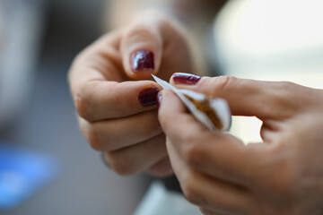 Close-up of a woman's hands carefully preparing a hand-rolled cigarette with tobacco and rolling paper