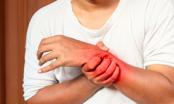 A Man has pain in her wrist. Health care concept. Pain points are highlighted in red. close up