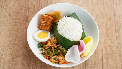 Nasi Gudangan, rice served with various vegetable with grated coconut seasoned and various side dishes. Indonesian food