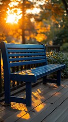 A sunlit blue bench sits on a wooden deck, bathed in warm light from a vibrant autumn sunset