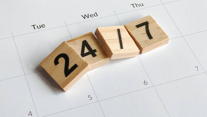 Wooden blocks forming the number 24/7 on a calendar, symbolizing continuous business service, all-day support, non-stop operation, and time management.