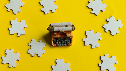 Miniature vintage typewriter surrounded by scattered white puzzle pieces, representing the complex...