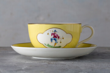 Yellow Cup and Saucer with Hand Painted Oriental Figures T.Goode Commission England 1900s
