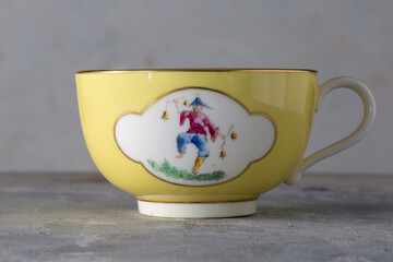 Yellow Cup and Saucer with Hand Painted Oriental Figures T.Goode Commission England 1900s