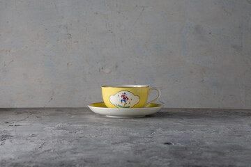 Yellow Cup and Saucer with Hand Painted Oriental Figures T.Goode Commission England 1900s