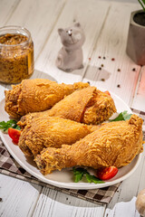Crispy fried chicken drumsticks on white plate
