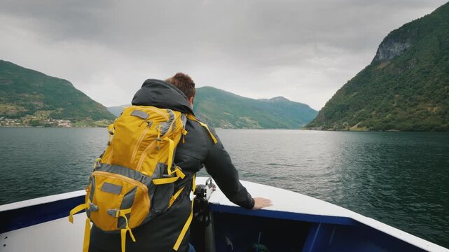 A Man With A Backpack Travels Through A Picturesque Fjord In Norway Standing On The Bow Of The Ship 4k video
