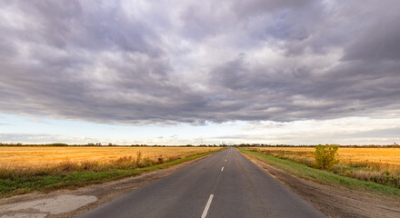 Long road with a cloudy sky in the background