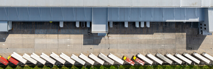 Aerial view modern warehouse for trucks unloading and loading, semi truck cargo trailer at logistic park warehouse, Distribution warehouse shipping supply chain, Business transportation logistic.