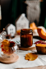 black candle and tea with autumn leaves create intimate cozy fall still life