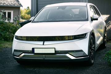 White electric SUV parked in suburban driveway