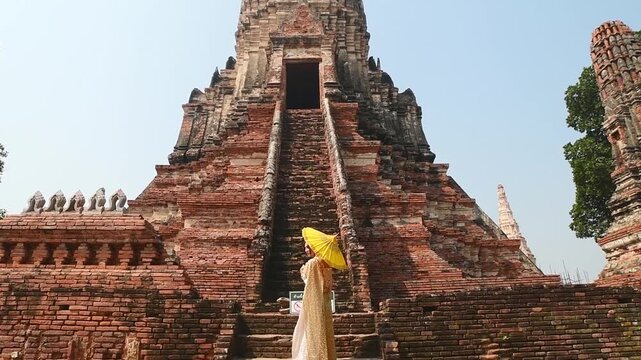 Thailand, Ayutthaya - march 15th, 2023: Woman in traditional Thai dress pose sightseeing visit ancient Buddha statue.Ayutthaya historical park. UNESCO World Heritage Site