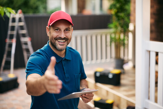 Happy handyman offering handshake while looking at camera.