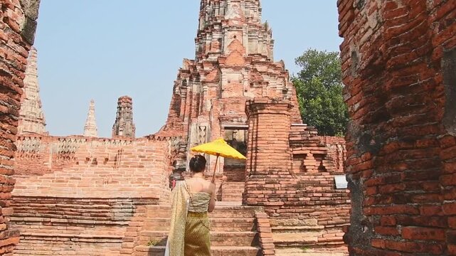 Thailand, Ayutthaya - march 15th, 2023: Woman in traditional Thai dress pose sightseeing visit ancient Buddha statue.Ayutthaya historical park. UNESCO World Heritage Site