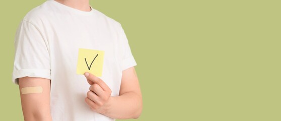 Young man holding paper with DONE mark on green background with space for text, closeup. Vaccination concept © Pixel-Shot