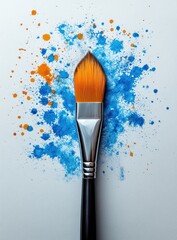 Paintbrush with colorful splatters on white paper