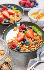 Granola bowls with berries, yogurt, nuts, and honey for breakfast