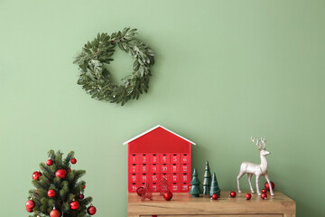 Advent calendar with decor on commode and Christmas wreath in room
